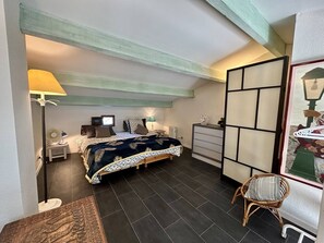 A bedroom with a bed, bedside tables, a lamp, a dresser, a chair, and a view of the outside. - Apartment sea view, parking - 6 guests (Saint-Cyprien)