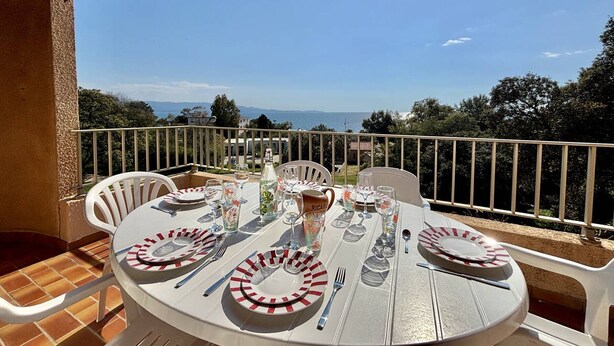 A round table with plates, cutlery, and glasses set for a meal, overlooking a scenic view. - Terraced house, sea view - 6 guests (Ajaccio)