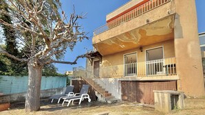 A two-story building with a balcony, a staircase, and a tree in the yard. - Terraced house, sea view - 6 guests (Ajaccio)