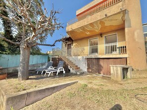 A two-story building with a balcony, a staircase, and a tree in the yard. - Terraced house, sea view - 6 guests (Ajaccio)