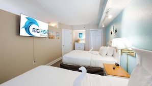 Et hotelværelse med en seng, et fjernsyn der viser 'BIG FISH Rentals', et natbord og et sengebord.