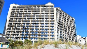 Et hotel med flere etager, ensartet facade, mange balkoner og et fladt tag.