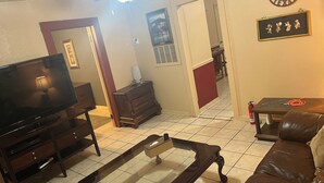 A living room with a television, a pool table, a leather sofa, a red door, and a wall clock. - 2-bedroom house in enchanting Bandera with cool AC breeze (Bandera)