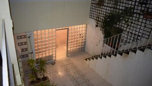 A courtyard with a tiled floor, a metal gate, and potted plants. - Sport Hostel Figueira da Foz (Figueira da Foz)