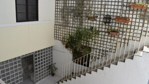 A multi-level building with a staircase, a window, and a wall with a grid pattern. - Sport Hostel Figueira da Foz (Figueira da Foz)