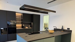 Una cocina moderna con una isla central, electrodomésticos integrados y un diseño elegante.