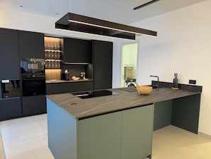 Una cucina moderna con isola centrale, elettrodomestici integrati e un design elegante.