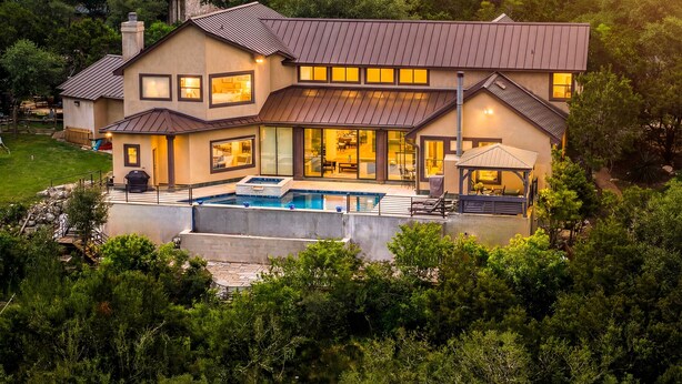 A large, modern house with a swimming pool, multiple rooms, and a view of the cityscape. - La Cresta: Hill Country Retreat with Heatable Pool, Fitness Room & Views (Helotes)