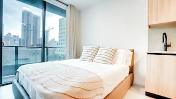 Suite estudio Deluxe, balcón, vista a la ciudad | Sábanas de algodón egipcio, ropa de cama de alta calidad y edredón