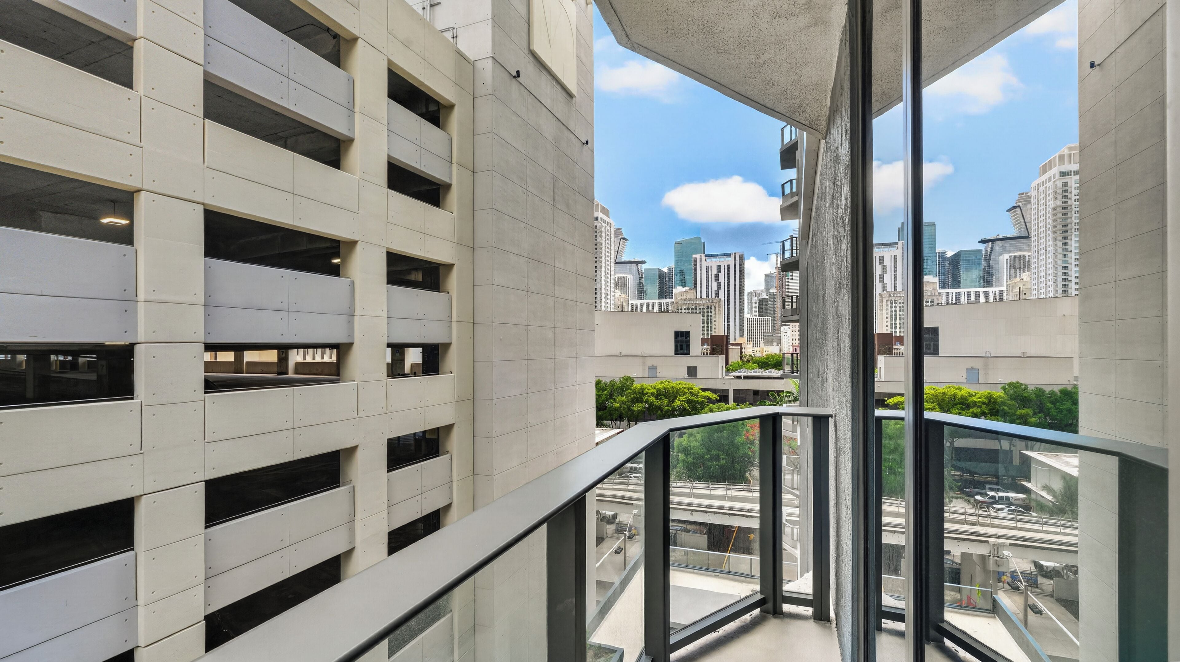 A modern building with a glass balcony overlooking a cityscape.