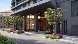 A modern hotel entrance with a covered walkway, large windows, and a parking area. - The Urban Suites - 501 First Residence (Miami)