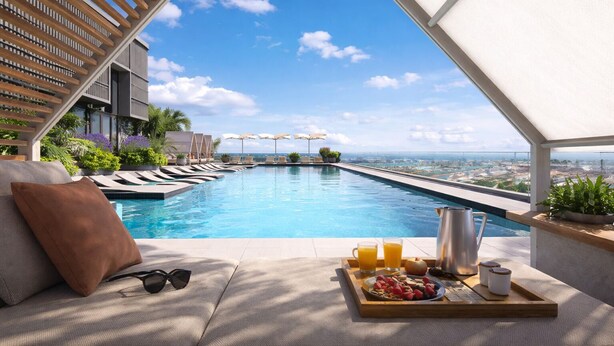 A rooftop pool with lounge chairs, a tray with snacks and drinks, and a city view. - The Urban Suites - 501 First Residence (Miami)