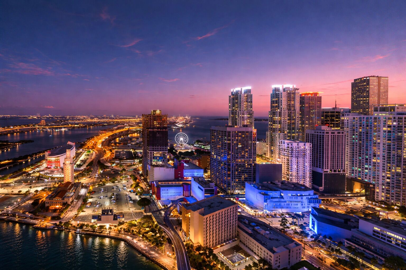 A cityscape with high-rise buildings, a waterfront, and a bridge.