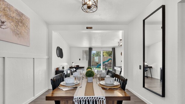 A dining area with a wooden table, chairs, and a central plant. - 4BR Oasis w/pool, Cold Plunge, Gym, Game Room (Phoenix)