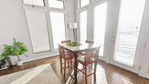 A dining area with a table, chairs, a lamp, and a potted plant. - Houston Townhome w/ Skyline Views & Rooftop Patio (Houston)