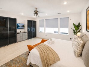 A bedroom with a bed, a wardrobe, a desk, and a window.