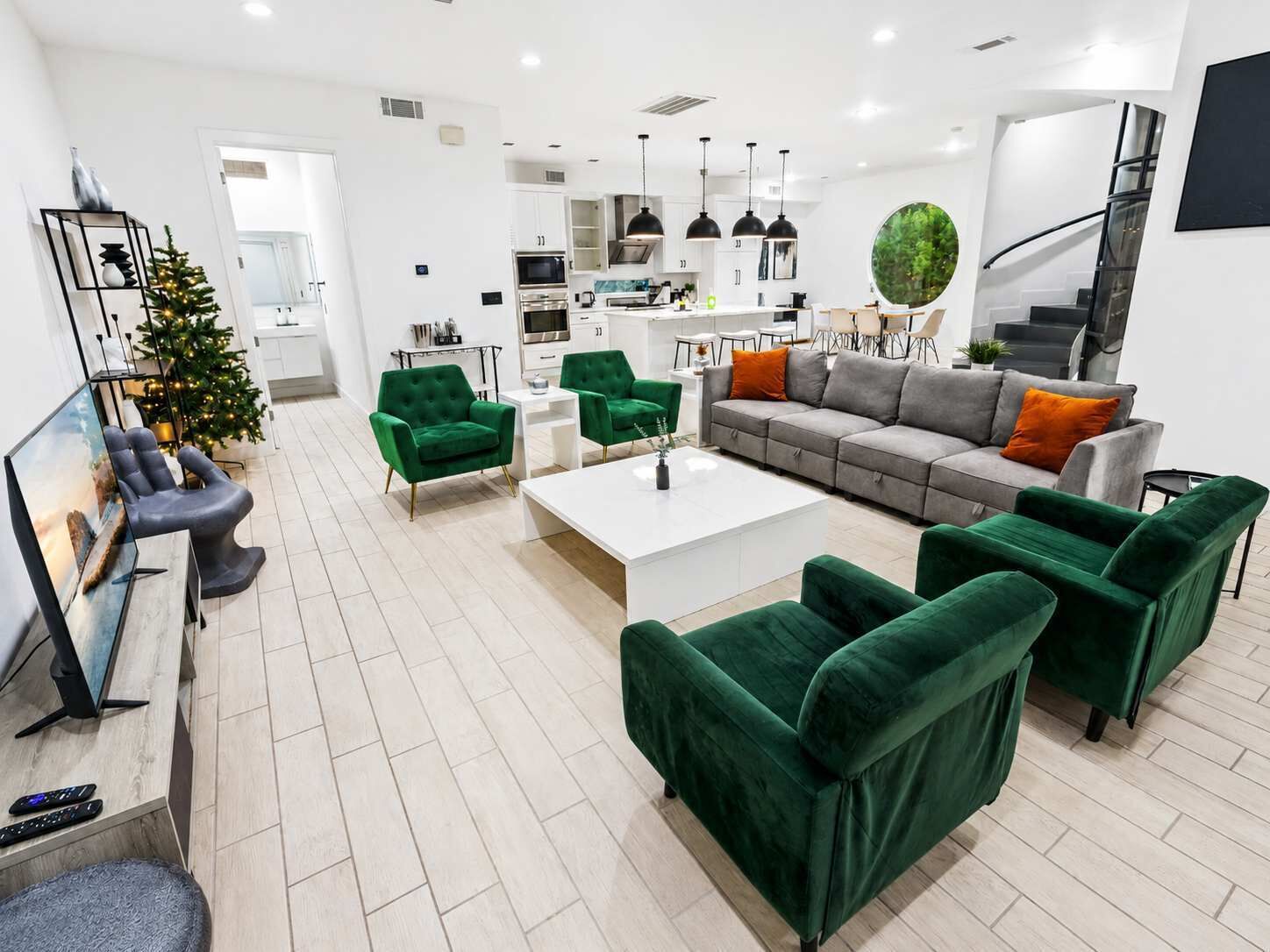 A modern living room with a sofa, chairs, a coffee table, and a TV.