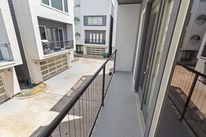 Ein mehrstöckiges Wohngebäude mit Balkonen, einer Garage und einem Betonweg.