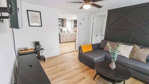 Ein modernes Wohnzimmer mit Sofa, Couchtisch und Deckenventilator.