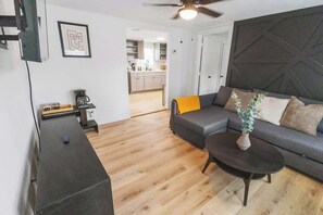Ein modernes Wohnzimmer mit Sofa, Couchtisch und Deckenventilator.