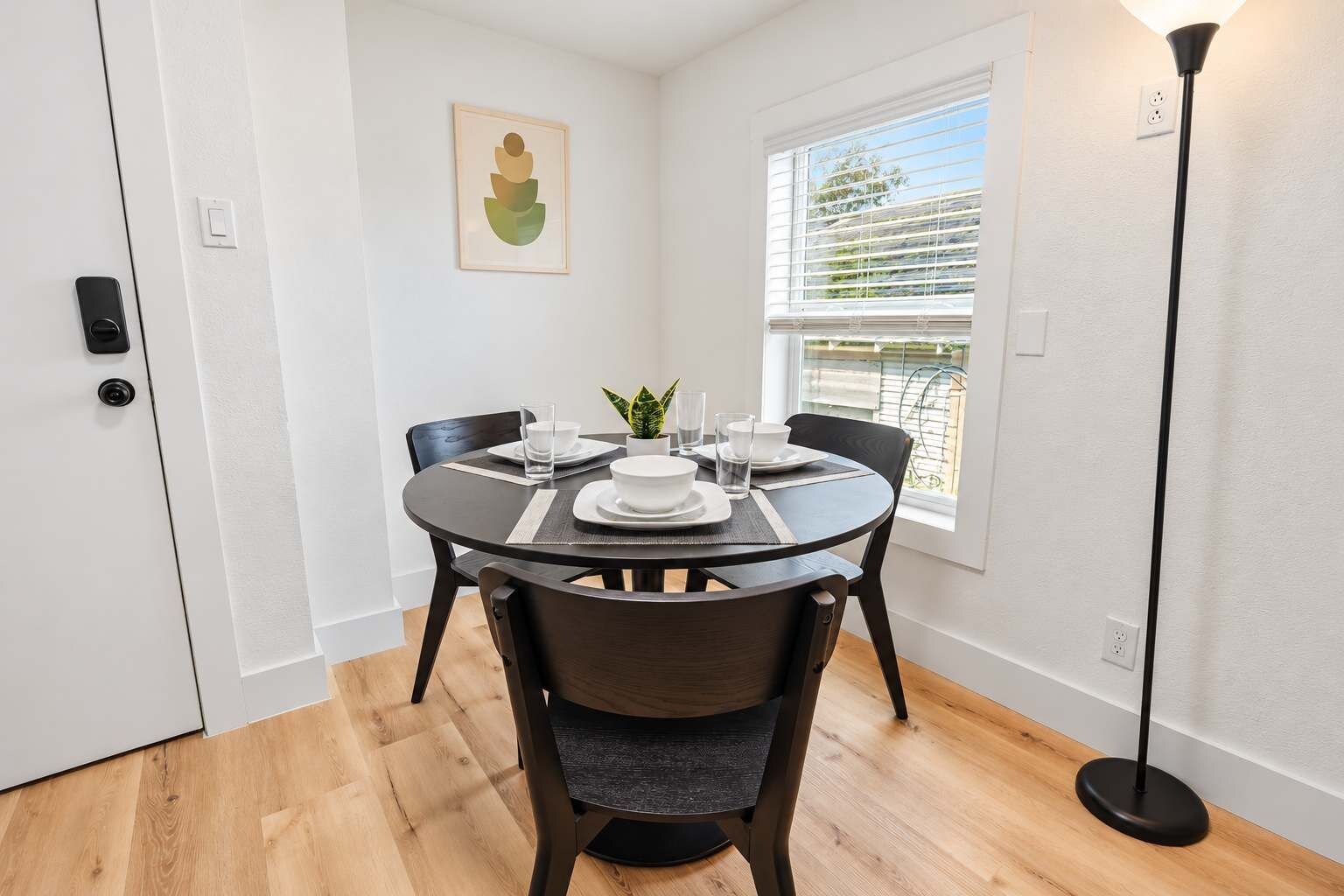 Un coin repas avec une table ronde, des chaises et une plante en pot.