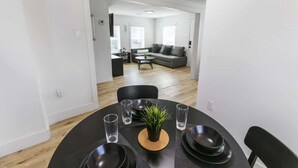 A dining area with a round table, black chairs, and a small potted plant. - 1BR Loft Near TSU + Med Center | Assigned Parking | Third Ward Houston 3 (Houston)