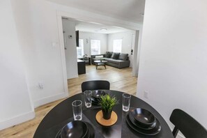 A dining area with a round table, black chairs, and a small potted plant. - 1BR Loft Near TSU + Med Center | Assigned Parking | Third Ward Houston 3 (Houston)