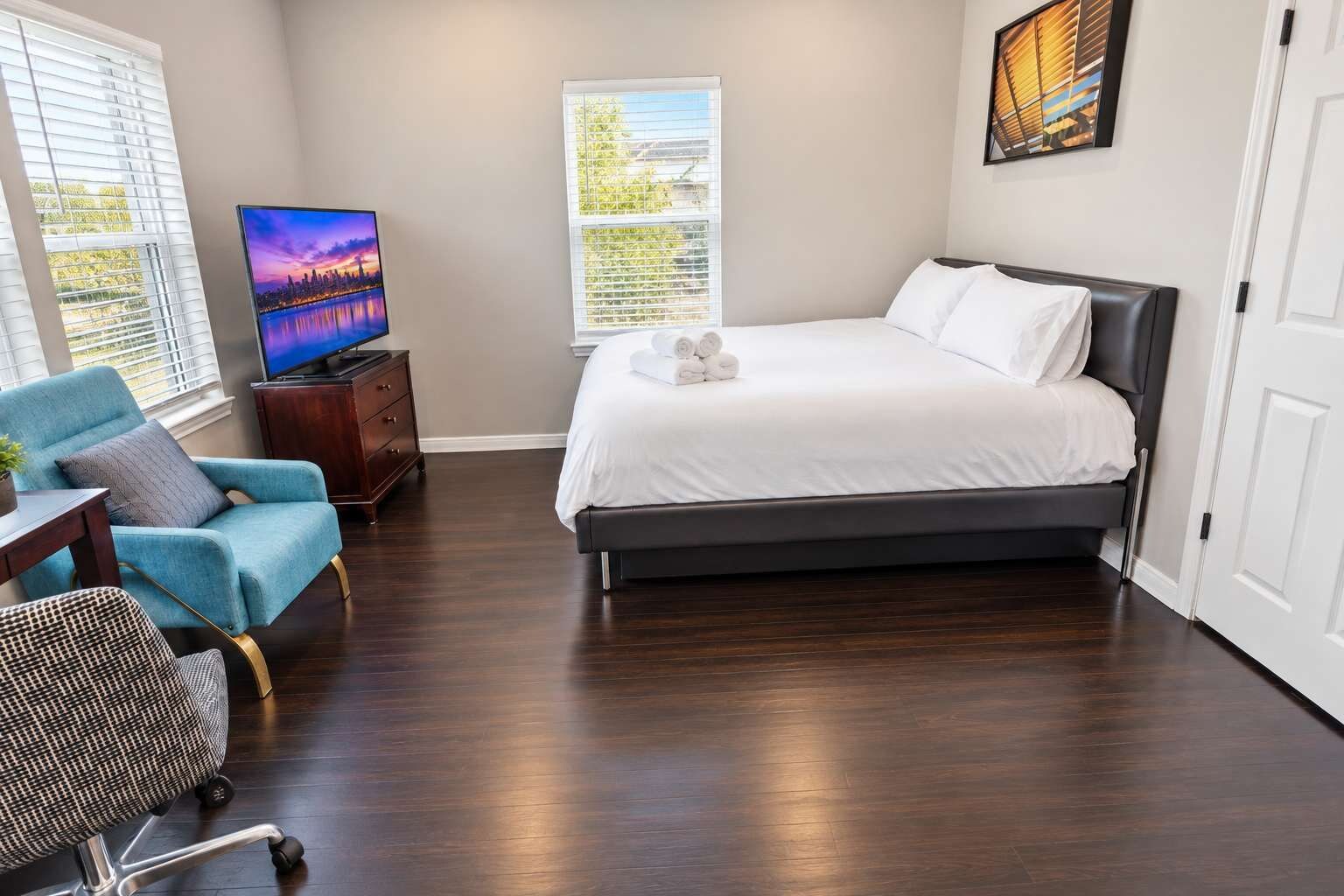 Une chambre d’hôtel avec un lit, une télévision, une chaise et un bureau.