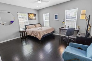Une chambre à coucher avec un lit, un bureau, une chaise et une lampe.