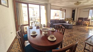 A dining area with a round table, chairs, and a sofa. - 114m² 3 Bedroom Apartment With Balcony Lift and AC (Nules)