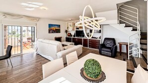 Un salon moderne avec un canapé, une table à manger et un escalier.