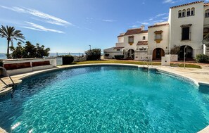 Una piscina cristalina con vistas a un edificio costero.