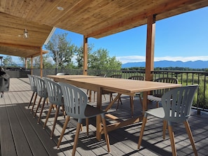 Eine Holzterrasse mit Tisch und Stühlen, mit Blick auf eine Berglandschaft.