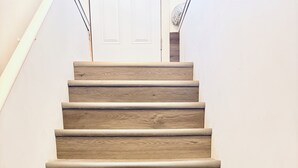 A wooden staircase with a white wall and a door at the top. - Everything you need! spacious 1 BR |Full Kitchen |Bathtub,W/D wifi |Near Airport (Moncton)