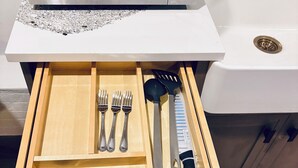 A kitchen drawer with utensils, a knife, and a microwave above it. - Everything you need! spacious 1 BR |Full Kitchen |Bathtub,W/D wifi |Near Airport (Moncton)