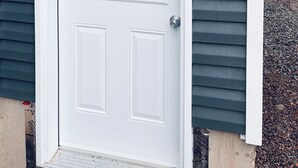 A white door with a window, a mailbox, and a wall-mounted light fixture. - Everything you need! spacious 1 BR |Full Kitchen |Bathtub,W/D wifi |Near Airport (Moncton)