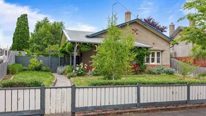 A residential house with a front yard, a wooden fence, and a clear sky. - Character-Filled, Modern Retreat In Mount Pleasant, Ballarat (Mount Pleasant)