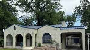 A building with a stone facade, arched windows, and a covered entrance.