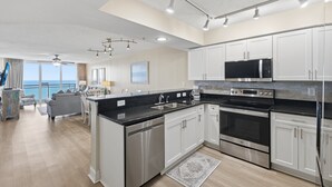 Een moderne keuken met roestvrijstalen apparatuur, witte kasten en een groot eiland.
