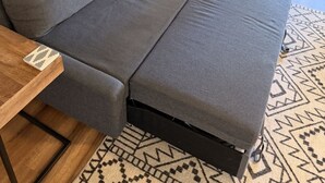 A grey sofa with a wooden side table and a patterned rug. - Mountain Modern Condo + Resort Amenities & Patio (Bend)