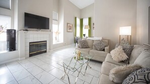 A living room with a fireplace, sofa, and television. - Welcome to your chic escape North Las Vegas perfect for relaxation and adventure (North Las Vegas)