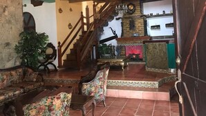 A spacious living area with a staircase, wooden furniture, and a fireplace.