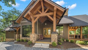 A lodge with a stone facade, wooden beams, and a covered porch. - Sundance Lodge at Eagles Nest - hot tub, mtn home, club amenities (Elk Park)
