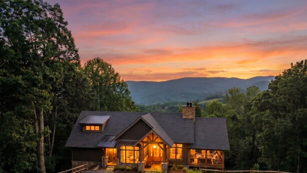 A house with a sloped roof, large windows, and a gravel driveway. - Sundance Lodge at Eagles Nest - hot tub, mtn home, club amenities (Elk Park)