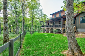 A two-story wooden house with a deck, surrounded by a forested area. - The Sugar Chalet - Luxury home on Sugar, easy access, views! (Sugar Mountain)