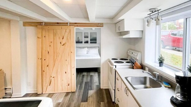A compact kitchen with a stove, sink, and window. - 1740 Le Cocon Limoilou Enfant-Jésus Hospital (Québec)