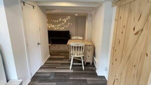 A narrow hallway with a wooden floor, a desk with a chair, and a sliding door on the right. - 1740 Le Cocon Limoilou Enfant-Jésus Hospital (Québec)