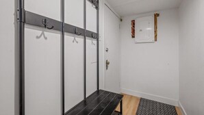 A room with a black bench, a coat rack, a door, and a wall-mounted electrical box. - Comfort & Practicality, 1 CH, Limoilou, Enfant-Jésus (Québec)
