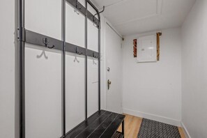 A room with a black bench, a coat rack, a door, and a wall-mounted electrical box. - Comfort & Practicality, 1 CH, Limoilou, Enfant-Jésus (Québec)