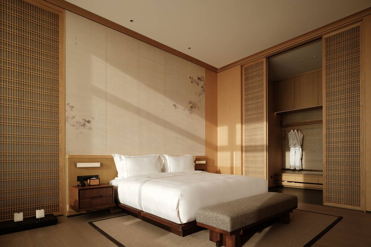 A bedroom with a bed, bedside tables, a bench, and a wardrobe.